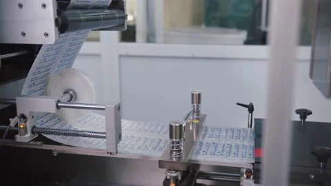 Automated pharmaceutical equipment is manufacturing the blister pack for pills Stock Footage 200856482