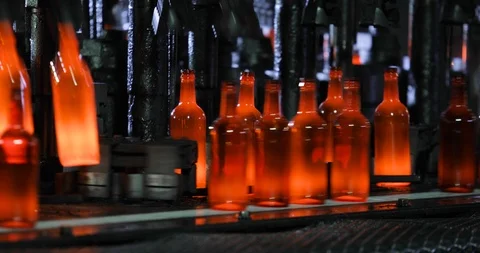 Automated process of forming bottle of molten glass on conveyor line in plant. Stock Footage 122483775