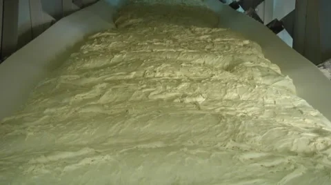 Automated production of bread. Dough at the bakery moves on conveyor belt Video stock 61074031