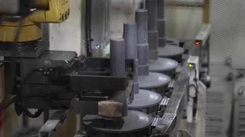 Automated production line featuring a robotic arm handling vertical cylindrical Vidéo 332918119