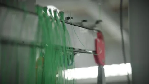 Automated robot hangs finished temperature sensor cables onto a storage rack Stock Footage 328830287