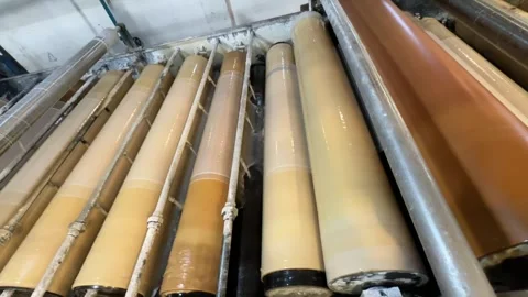 Automated textile merchandising machine running fabric rolls in factory Video stock 328002971