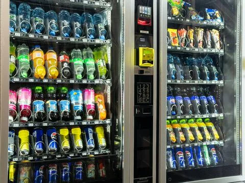 Automated vending machine filled with assorted bottled beverages and snack Stock Photos
