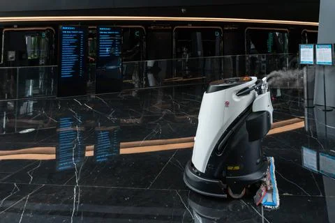 Automatic AI cleaner mopping floor inside of a modern office building. Fotos de archivo