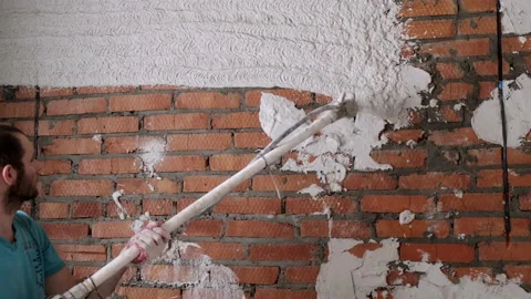 Automatic Application of Plastering Mixture to Brick Wall. Builder with Sprayer Stock Footage 168354325