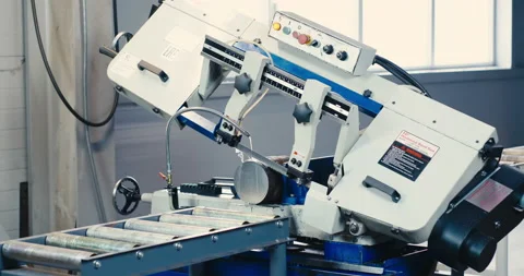Automatic band saw with coolant cuts metal rods of workpieces, industrial band Stock Footage 167557643