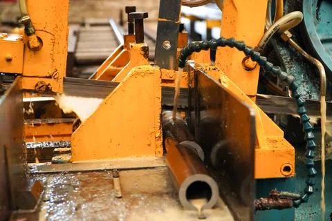 Automatic band saw machine cutting the metal rod with water base coolant me.. Stock Photos