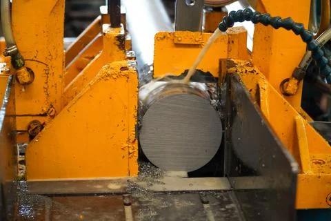 Automatic band saw machine cutting the metal rod with water base coolant me.. Stock Photos