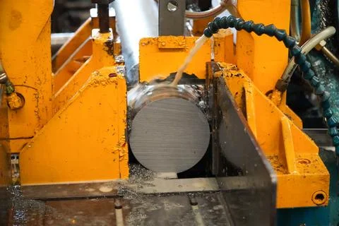 Automatic band saw machine cutting the metal rod with water base coolant me.. Stock Photos