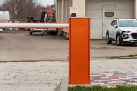 An automatic barrier gate stands closed at a parking lot entrance, ensuring.. Stock Photos