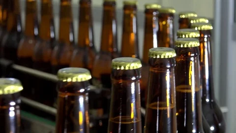 Automatic Beer Bottling Line. Queue of ready filled bottles on the conveyor. Stock Footage 84606825