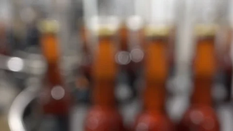 Automatic Beer Bottling Line. Queue of ready filled bottles. Out of focus Video stock 87686410