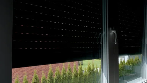 Automatic blinds closing over window in room Stock Footage 334672947