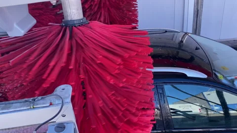 Automatic car wash brushes cleaning a black vehicle Stock Footage 333038014
