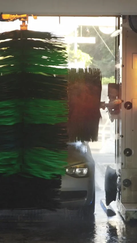 Automatic car wash in process - large brushes wash the machine at the front Stock Footage 329547317