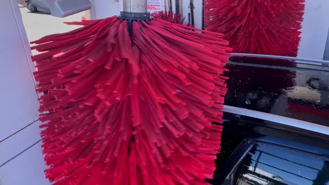 Automatic car wash red brushes cleaning vehicle surface Stockbeeldmateriaal 332789672