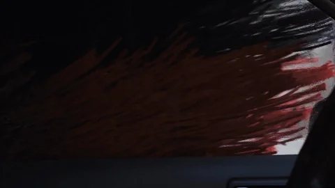 Automatic car washing action, heavy long red and black cleaning brushes running Stock-Footage 129369653