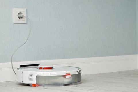 Automatic charging of the robot vacuum cleaner. Smart Home Concept Stock Photos