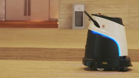 Automatic cleaning robot is vacuuming the carpet of the room. Stock Footage 232233496