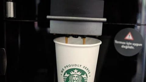 Automatic Coffee machine is pouring a coffee into the take away cup Stock Photos