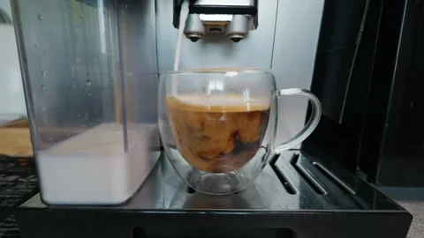 Automatic Coffee Maker Pouring Milk Into Espresso in Clear Glass Cup Stock Footage 339178860