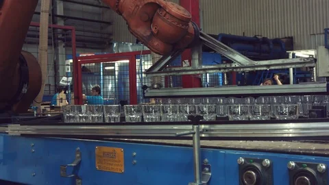 Automatic conveyor line or belt with rows of transparent crystal stemware in ind Stock Footage 121360169