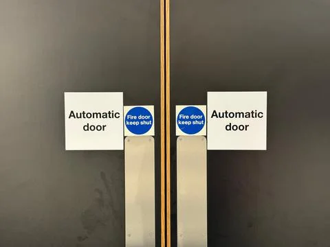 Automatic door keep shut sign on fire door Stock Photos