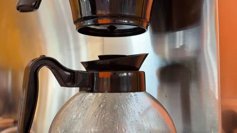 Automatic drip coffee maker brewing fresh filter coffee into a glass carafe in Stock Footage 345181979