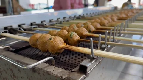 Automatic electric grill frying meatballs on skewers. Street food in Thailand Stock Footage 279205242