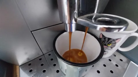 Automatic espresso machine pouring fresh hot coffee into an enamel mug Stock Footage 335826695