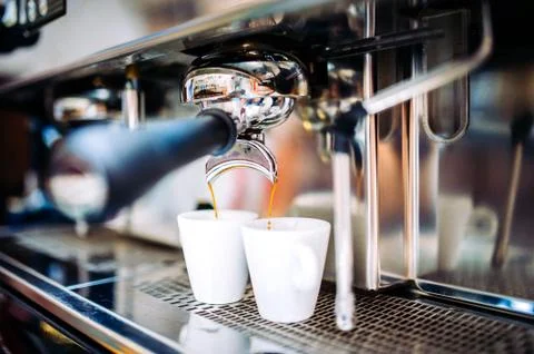 Automatic espresso machine pouring fresh brewed coffee into cups Stock Photos