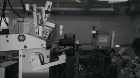 Automatic feeding of leaflets with instructions into boxes with products. Stock Footage 306576795