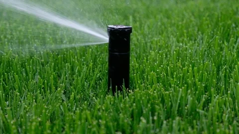 Automatic garden irrigation system watering lawn.Watering grass rom sprinkler ir Stock Footage 205264751