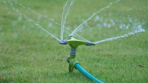 Automatic Garden Lawn sprinkler in action watering grass Stock Footage 71968038