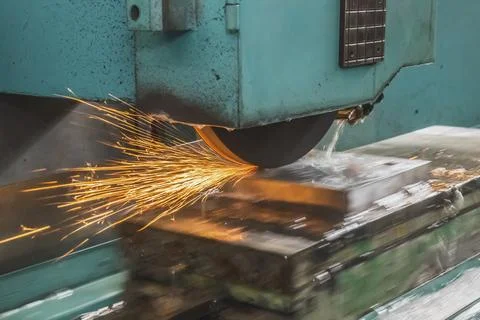 The automatic grinding machine polishes the part on a movable platform 스톡 사진