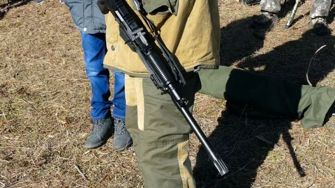 The automatic gun hangs on the hunter 스톡 동영상 123574197