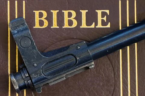 The automatic gun lying on the Bible, close up. Stock Photos