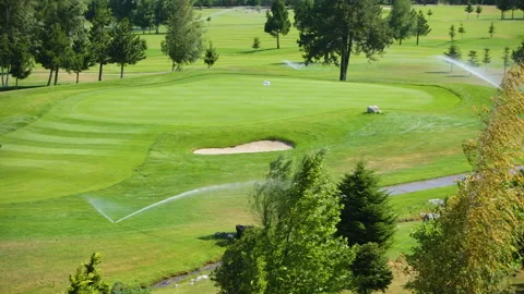 Automatic high-pressure water sprinkler at green golf course watering the grass. Stock Footage 255522579