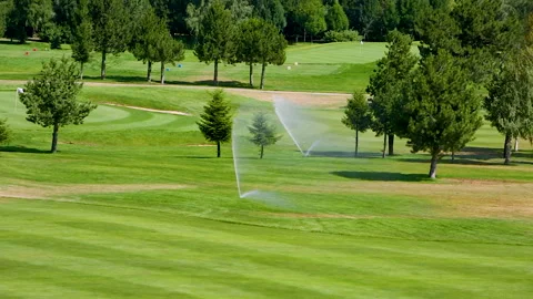 Automatic high-pressure water sprinkler at green golf course watering the grass. Stock Footage 255930891