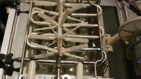 Automatic ice-making plant close-up. Water from the pipe flows into the tray. Th Stock Footage 129896388