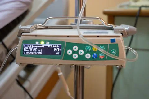 The automatic infusion device working beside the bed at hospital. Stock Photos