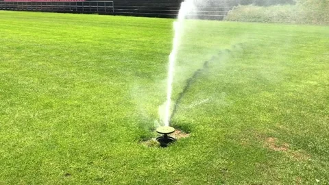 Automatic irrigate sprinkle watering grass at football field Stock Footage 130276935