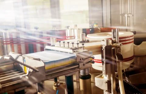 Automatic labeling machine during operation. Factory for the oil production. Stock Photos