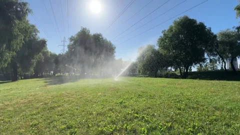 Automatic Lawn Irrigation System Watering Grass in Sunny Urban Park Stock Footage 341337465