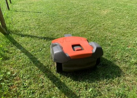 Automatic lawn mower robot moves on the grass, lawn. side view from above, copy Stockfoto's