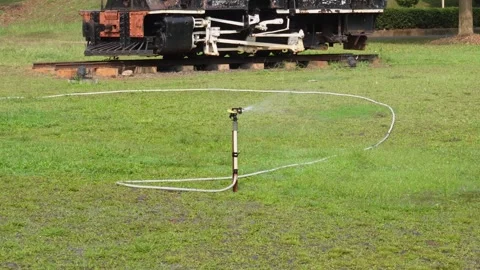 Automatic lawn sprinkler waters the grass in the garden Stock Footage 278115406