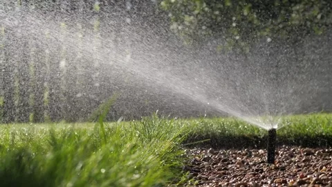 Automatic lawn watering sprinkler waters green lawn. Garden irrigation system Stock Footage 279087913