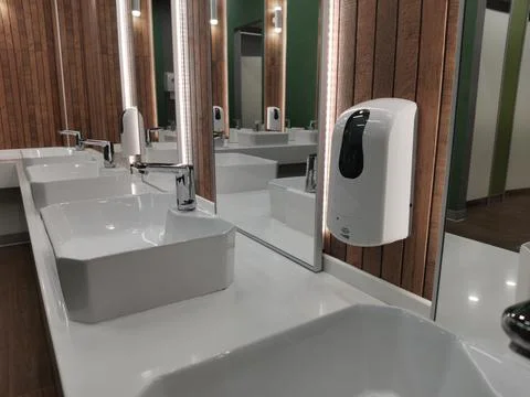 Automatic liquid soap dispenser in public toilet Stock Photos