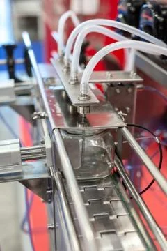 Automatic machine for filling and capping bottles. Stock Photos