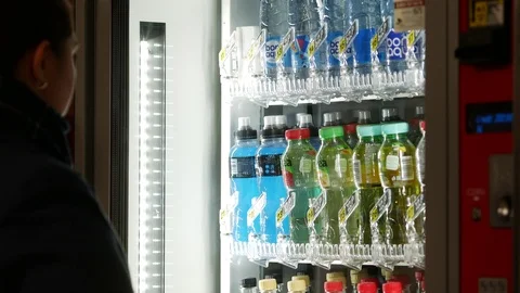 Automatic machine selling drinks in cans. Girl picks up a bottle Stock Footage 125632204